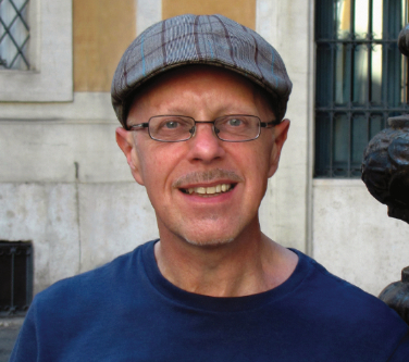 David Dubery in cap and spectacles smiling to camera